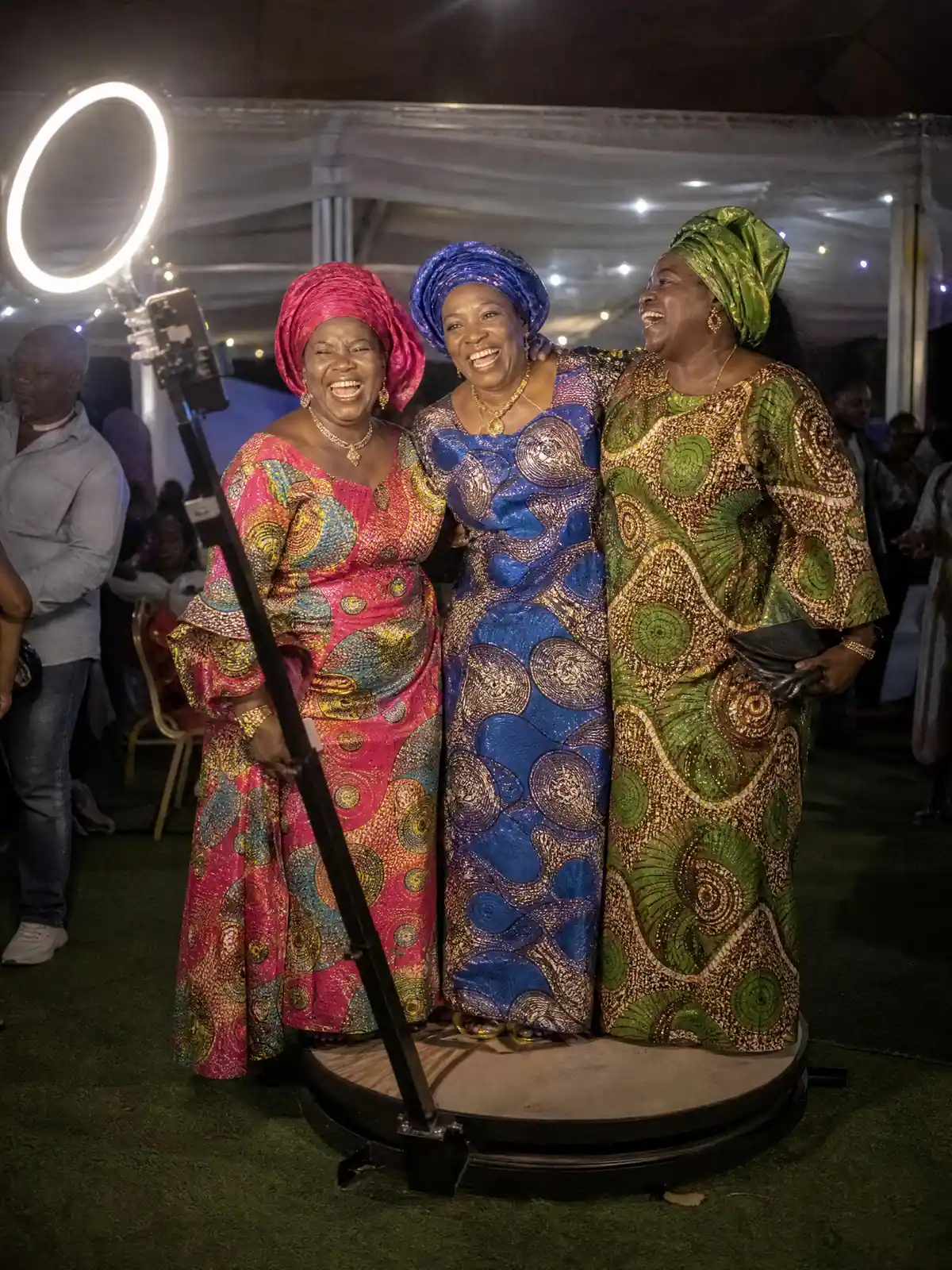 Aunties in colourful headwraps laughing as the 360 camera circles them