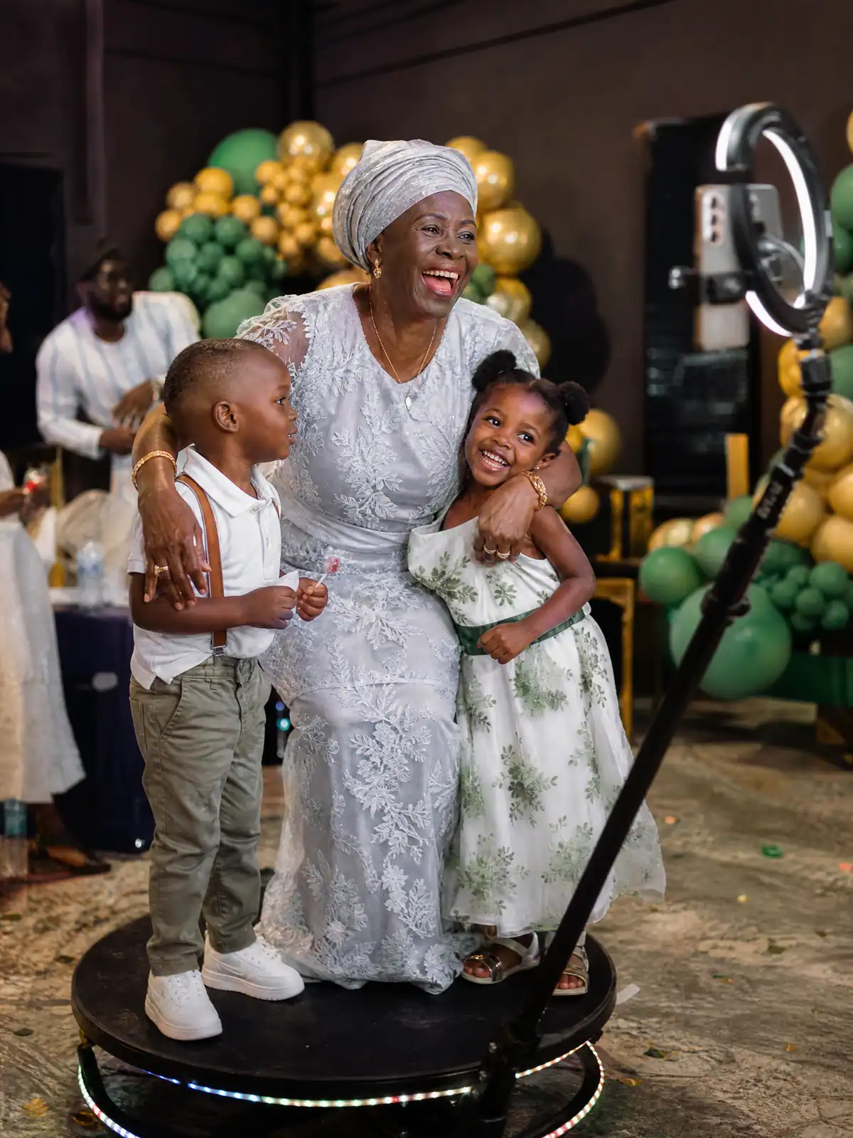 Grandmother and grandchildren laughing together on the 360 booth at her birthday